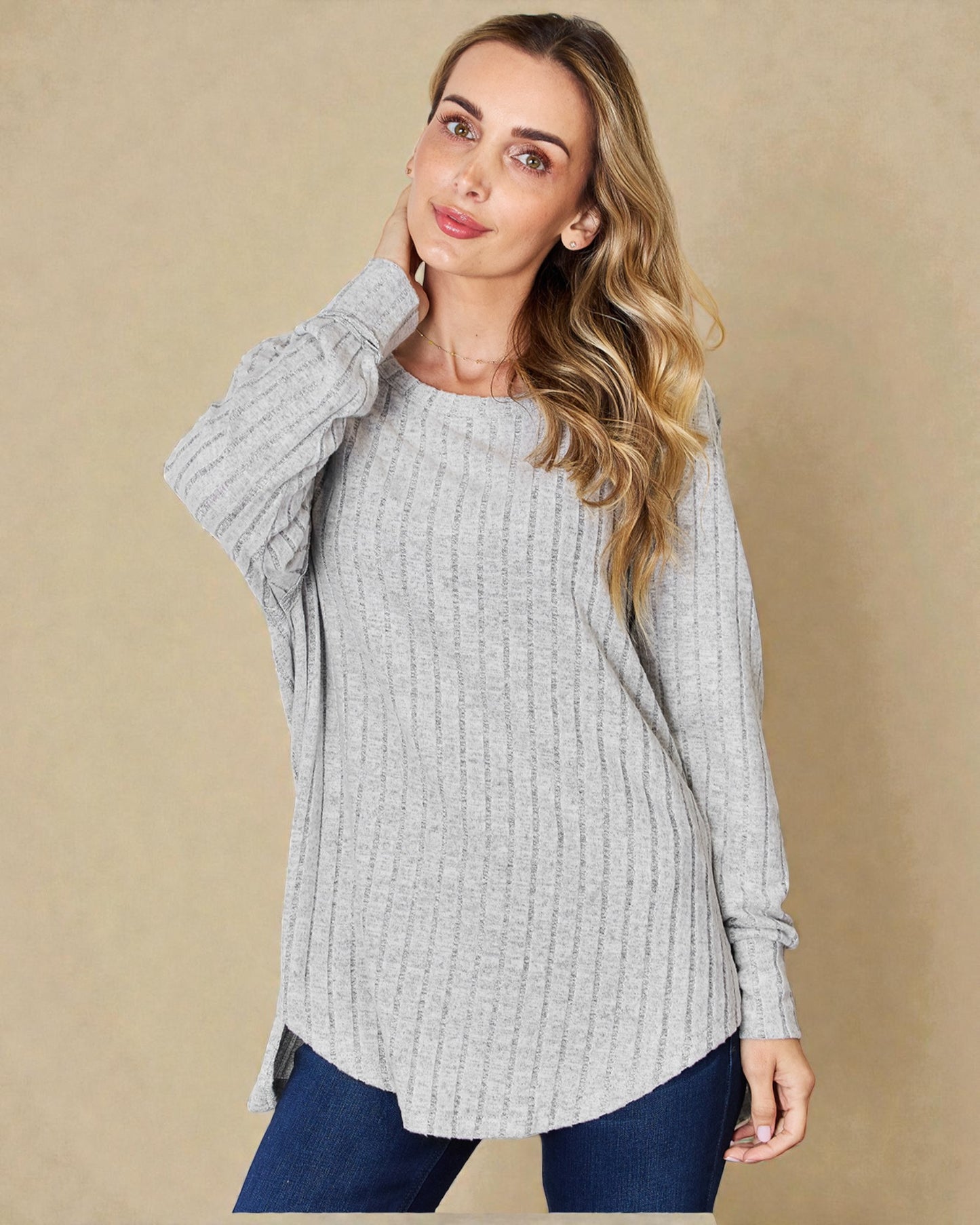 Woman wearing a gray sweater against a beige background