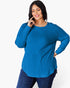 A woman modeling a bright blue ribbed knit long-sleeve top with a crew neck, paired with dark blue jeans, against a plain white studio background.