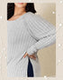 Gray ribbed sweater worn by a person on a beige background