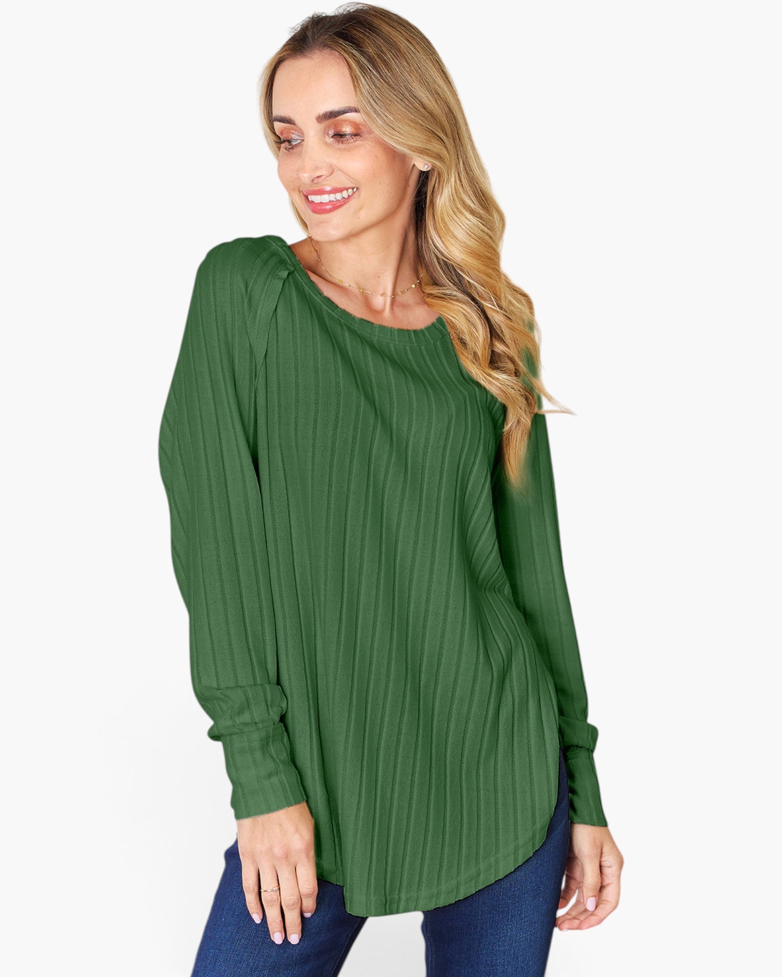 A woman wearing a green long-sleeve top with a vertical pleated texture, paired with blue jeans, against a plain white background.