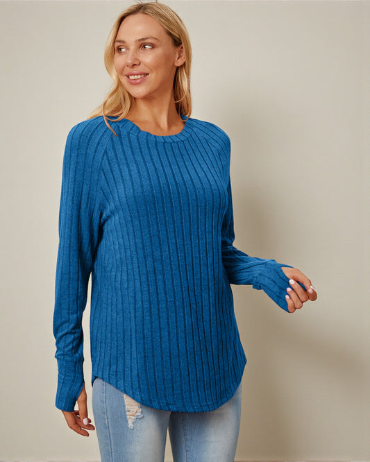 Woman wearing a blue ribbed sweater against a beige background
