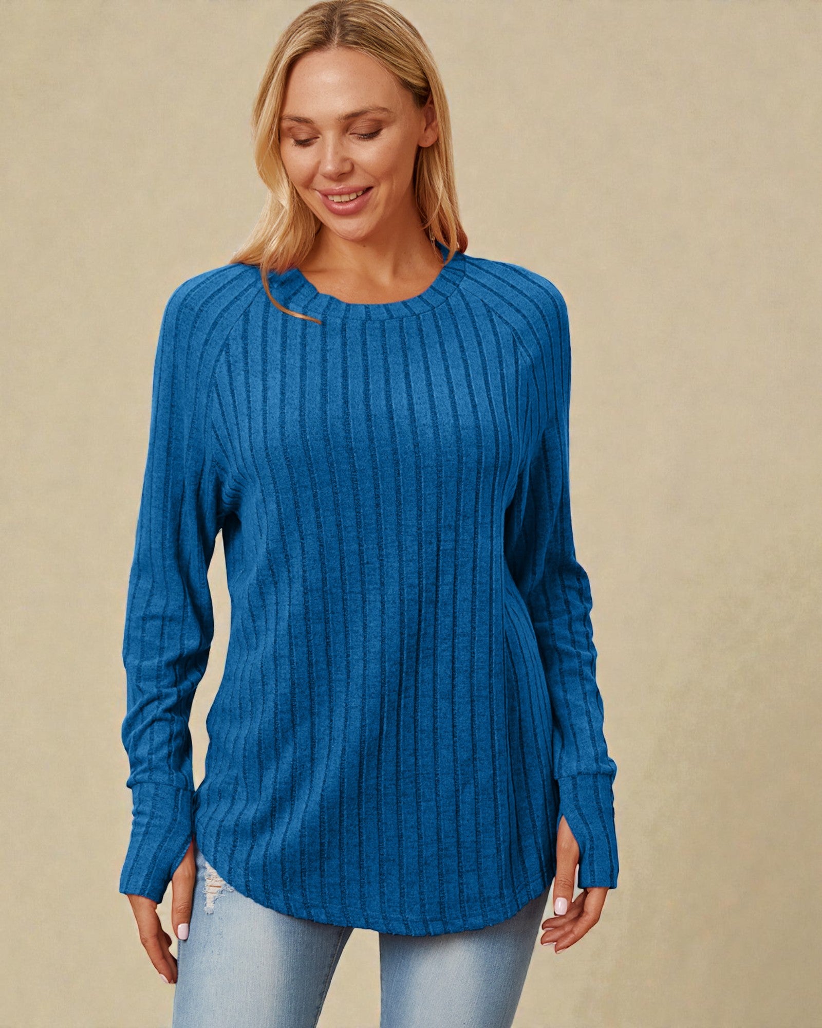 Woman wearing a blue ribbed sweater against a beige background