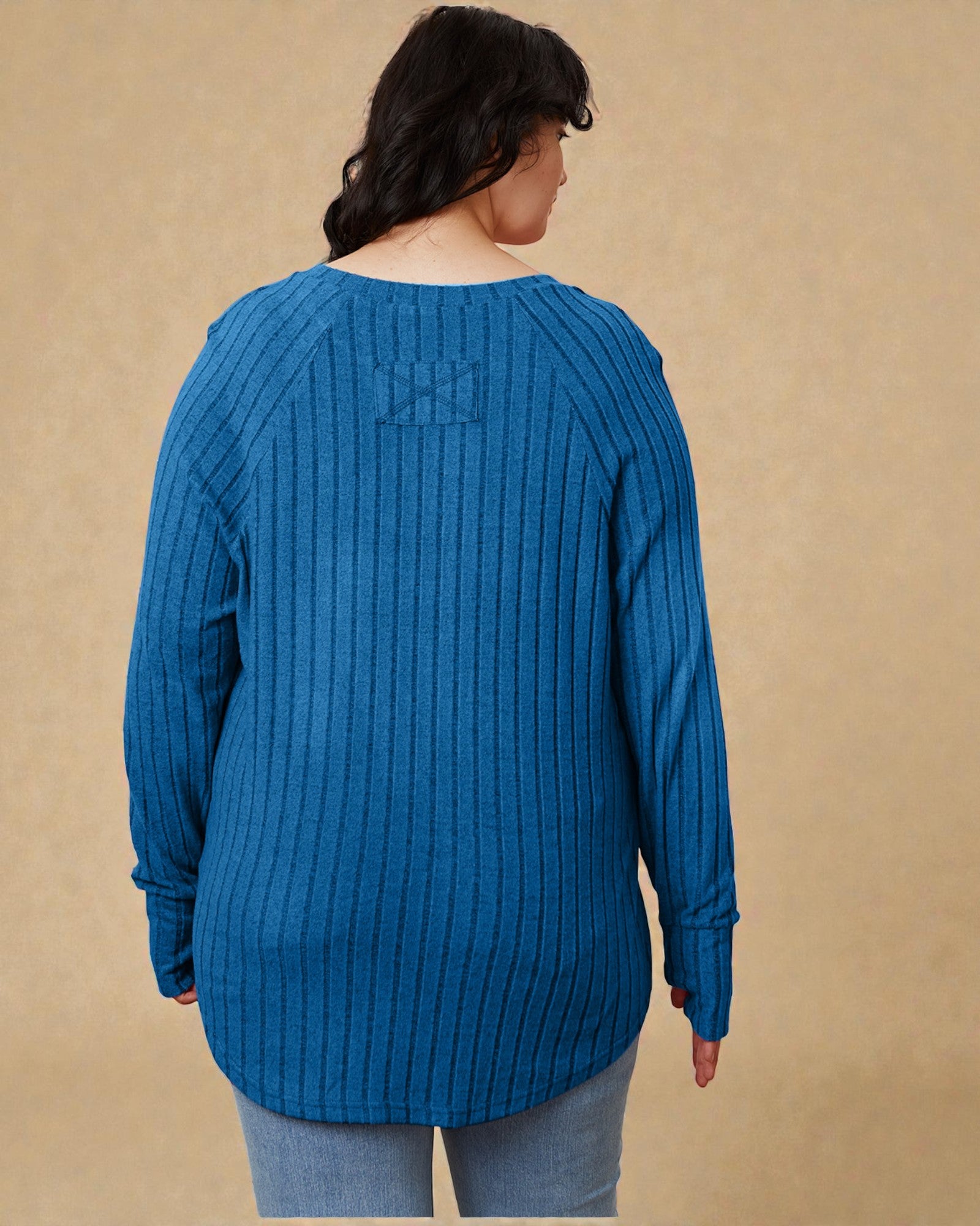 Person wearing a blue sweater against a beige background