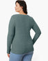 A woman shown from the back wearing a ribbed knit long-sleeve top in a muted sage green color, paired with light blue jeans, against a plain white background.