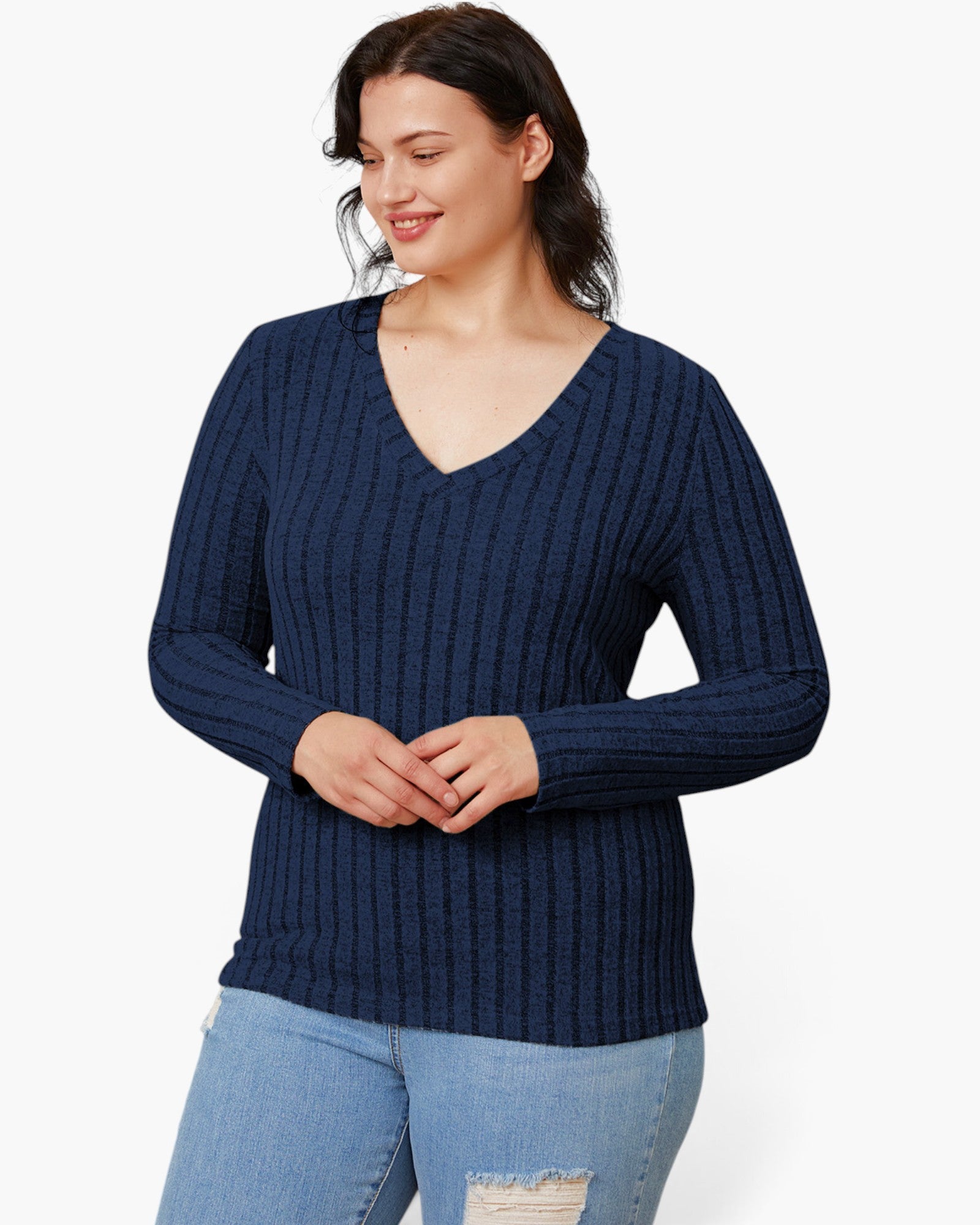 A woman wearing a navy blue ribbed knit long-sleeve sweater with a V-neck, paired with light blue jeans, against a plain white background.