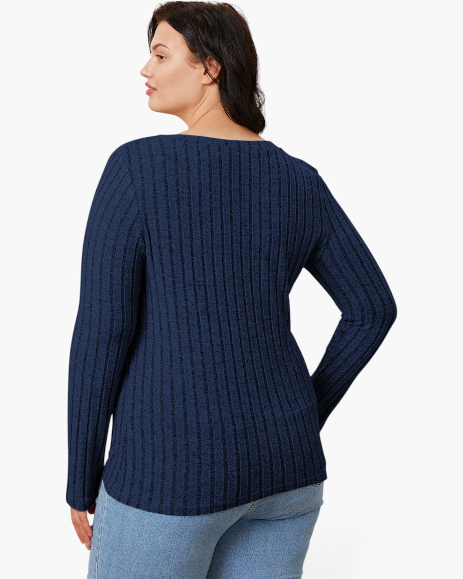 A woman shown from the back wearing a navy blue ribbed knit sweater and light blue jeans against a plain white studio background.