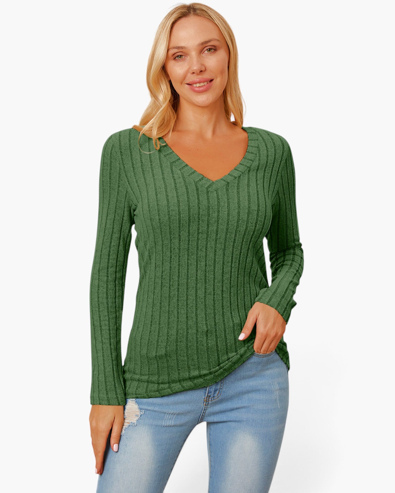 A woman wearing a green ribbed long-sleeve V-neck sweater and light blue jeans, standing against a plain white studio background.