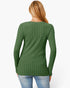 A woman viewed from the back wearing a green ribbed long-sleeve top and light blue jeans against a plain white background.