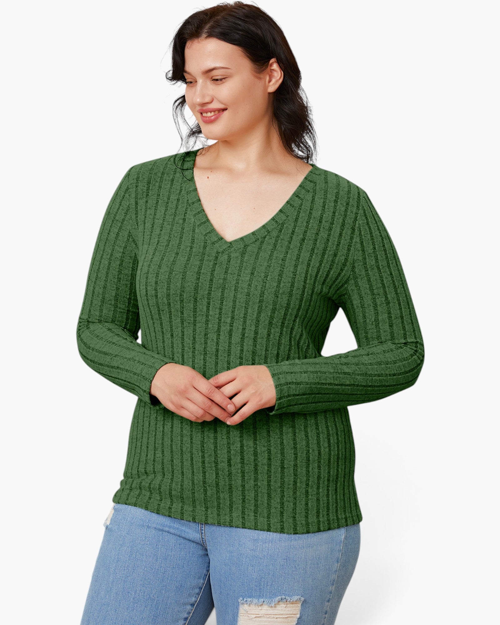 A woman wearing a green ribbed knit long-sleeve sweater with a V-neck, paired with light blue jeans, against a plain white background.
