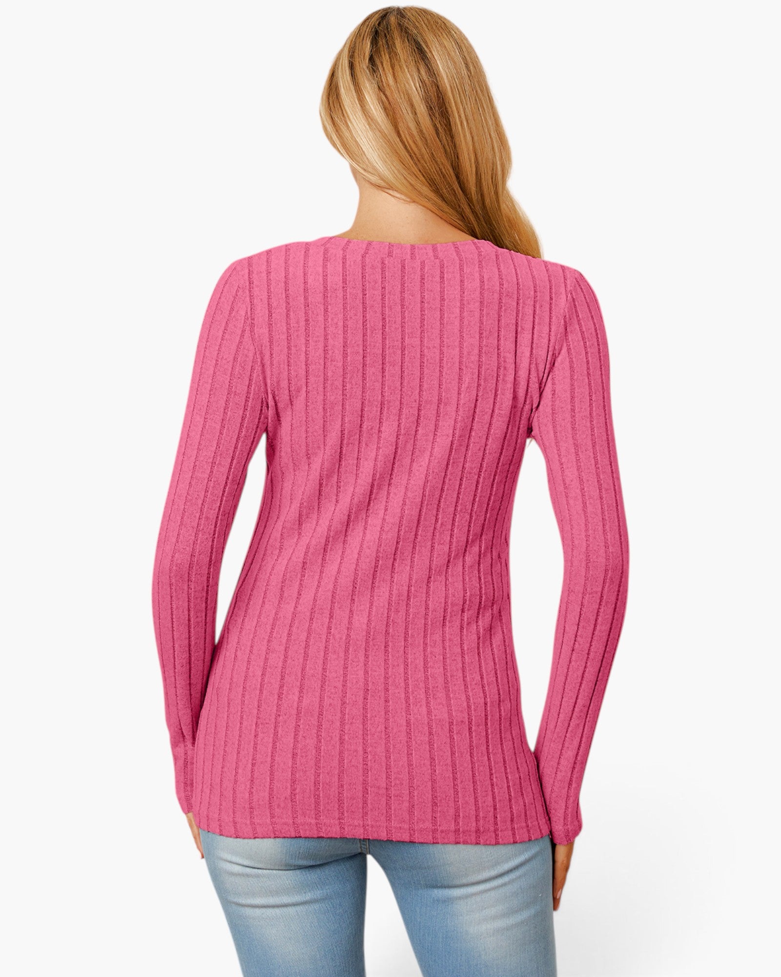 A woman viewed from the back wearing a pink ribbed knit long-sleeve top and light blue jeans against a plain white background.