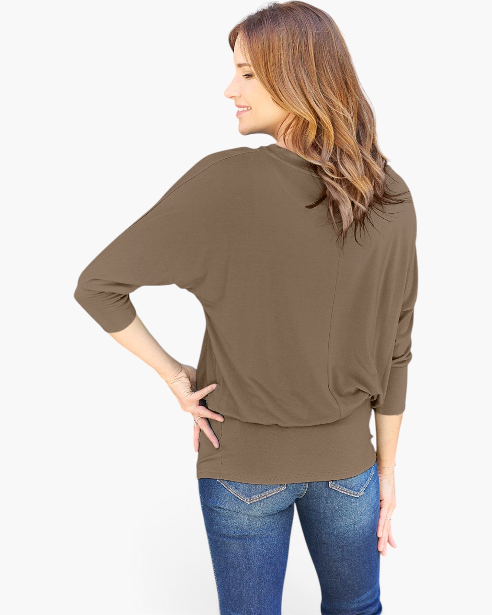 A woman shown from the back wearing a brown three-quarter sleeve top and blue jeans against a plain white background.