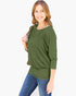 A woman modeling an olive green three-quarter sleeve top with a relaxed, slightly draped fit, paired with blue jeans against a plain white background.