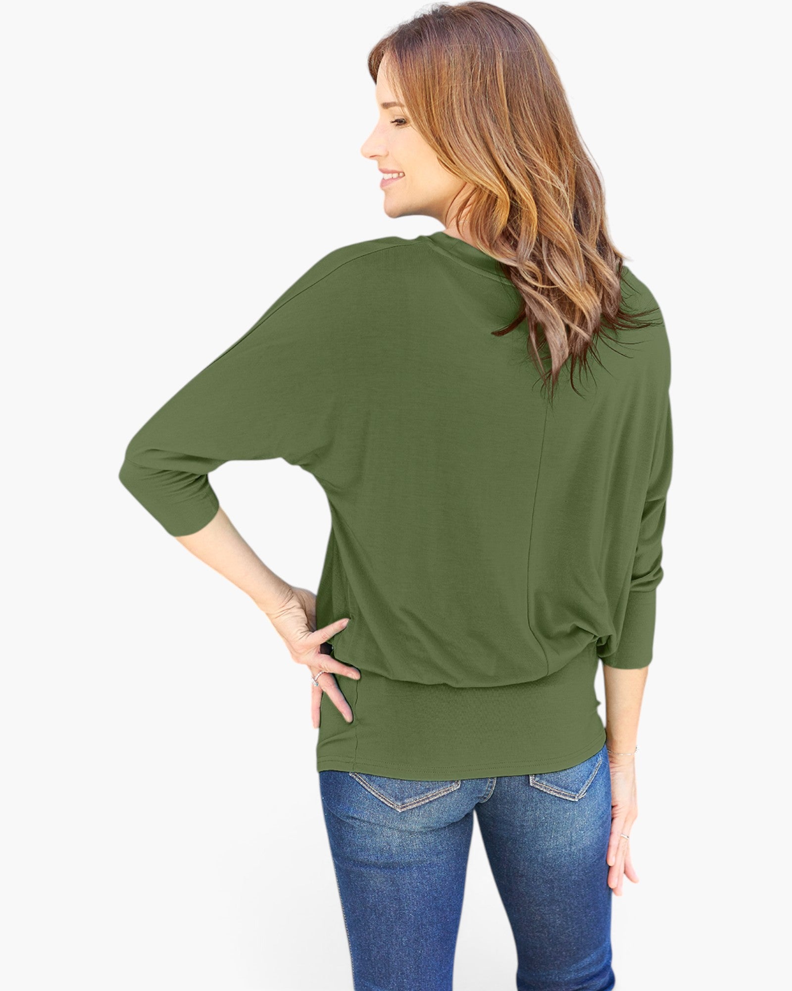 A woman shown from the back wearing an olive green long-sleeve top and blue jeans against a plain white background.