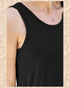 Black tank top worn by a person with a necklace featuring a small pendant on a beige textured background