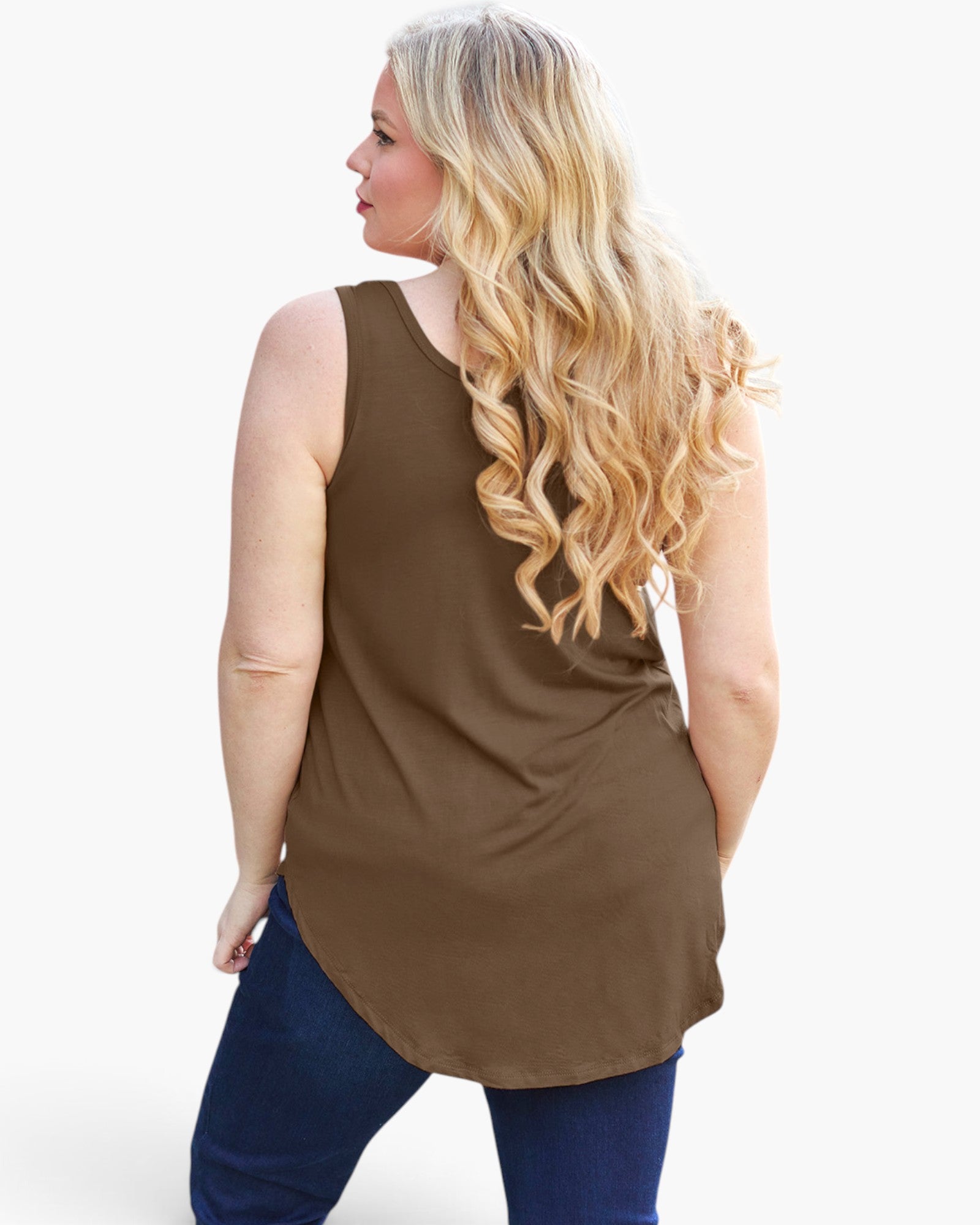 A woman with long blonde wavy hair is shown from the back wearing a sleeveless brown tunic top and dark blue jeans against a plain white background.