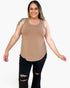 A woman modeling a scoop-neck tank top in a light tan color, paired with black ripped jeans, against a plain white background.