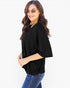 A woman modeling a black short-sleeve V-neck top with a relaxed, oversized fit, paired with blue jeans against a plain white background.