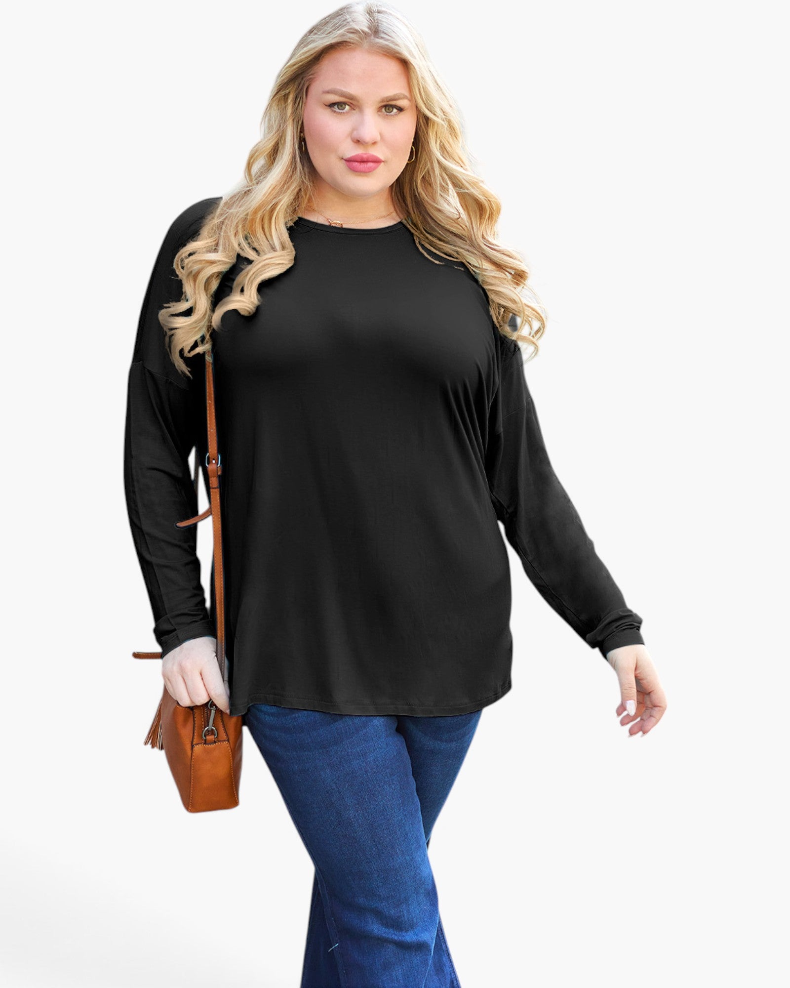 A woman modeling a black long-sleeve top with a relaxed fit, paired with blue jeans and carrying a brown leather shoulder bag, set against a plain white background.