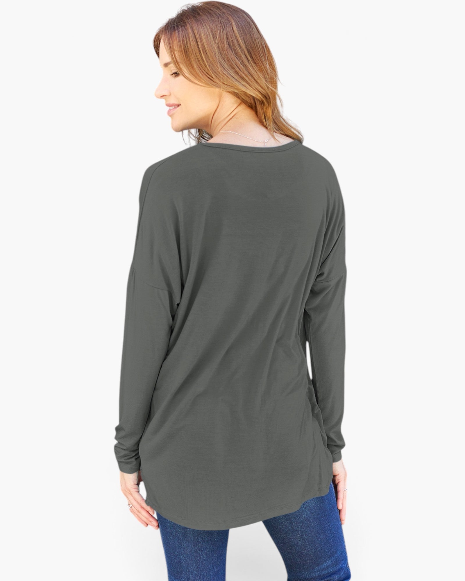 A woman wearing a dark gray long-sleeve tunic top with blue jeans, shown from a back-three-quarter view against a plain white background.