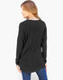 A woman shown from the back wearing a black long-sleeve tunic top and blue jeans against a plain white background.