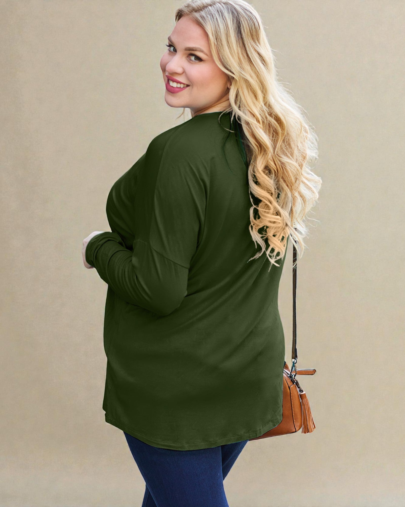 Woman wearing a green long-sleeve top with a beige background