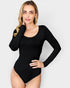 Woman wearing a black long-sleeve bodysuit against a white background
