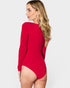Woman wearing a red swimsuit with long sleeves on a white background