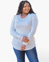 A woman modeling a light blue long-sleeve top with sheer mesh panel details on the shoulders and sleeves, paired with blue jeans, against a plain white background.