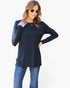 A woman modeling a dark navy long-sleeve tunic top with a chest pocket, paired with blue jeans, against a plain white background.