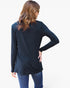 A woman shown from the back wearing a dark navy long-sleeve tunic top and blue jeans against a plain white background.