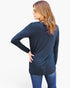 A woman wearing a dark navy blue long-sleeve tunic top and blue jeans, shown from a back-three-quarter view against a plain white studio background.