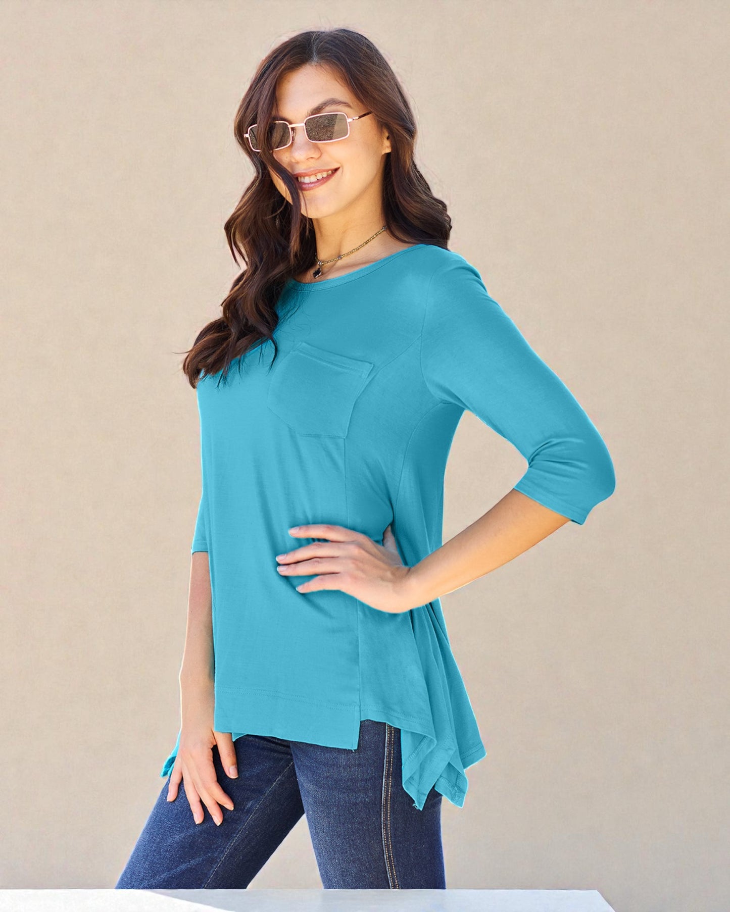 Woman wearing a turquoise top with a beige background