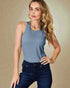 Woman wearing a blue tank top and dark jeans against a beige background