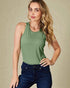 Woman wearing a green tank top and blue jeans against a beige background