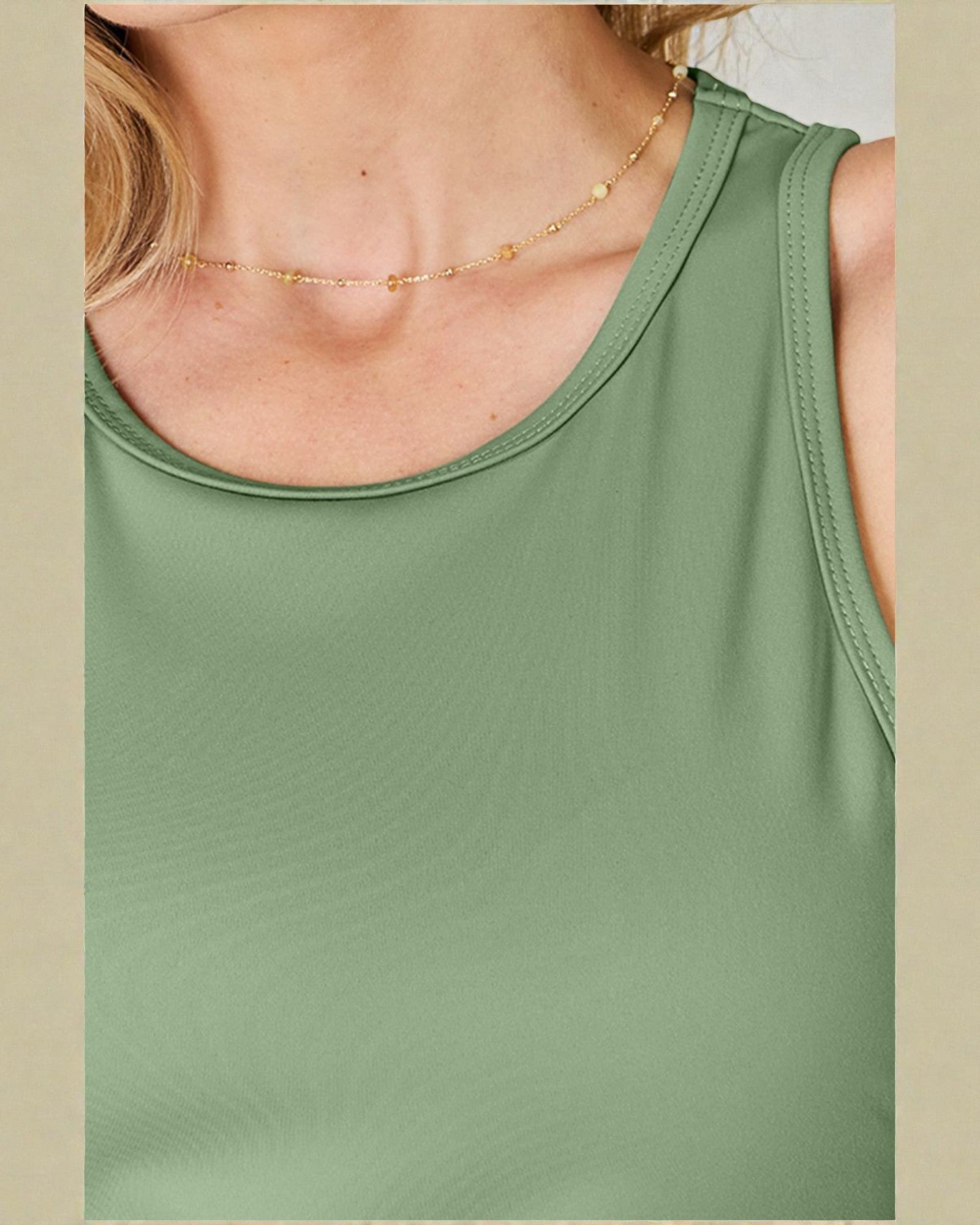 Green tank top worn by a person with a gold necklace.