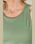 Green tank top worn by a person with a gold necklace.