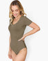 A woman modeling a short-sleeve, scoop-neck bodysuit in a solid olive green color, posed against a clean white background.