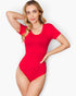 A woman modeling a bright red short-sleeve bodysuit against a clean light gray studio background.