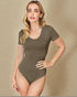Woman wearing a brown bodysuit against a beige background