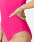 Close-up of a model wearing a bright hot pink one-piece swimsuit or bodysuit, showing the side hip and hand resting on the waistband, against a light gray background.