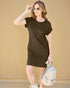Woman wearing a brown dress holding sunglasses and a small bag against a beige background