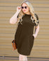 Woman wearing a brown dress with sunglasses against a wooden background