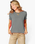 A woman wearing a short-sleeve crewneck t-shirt in a solid gray color, paired with beige pants, against a clean white background.