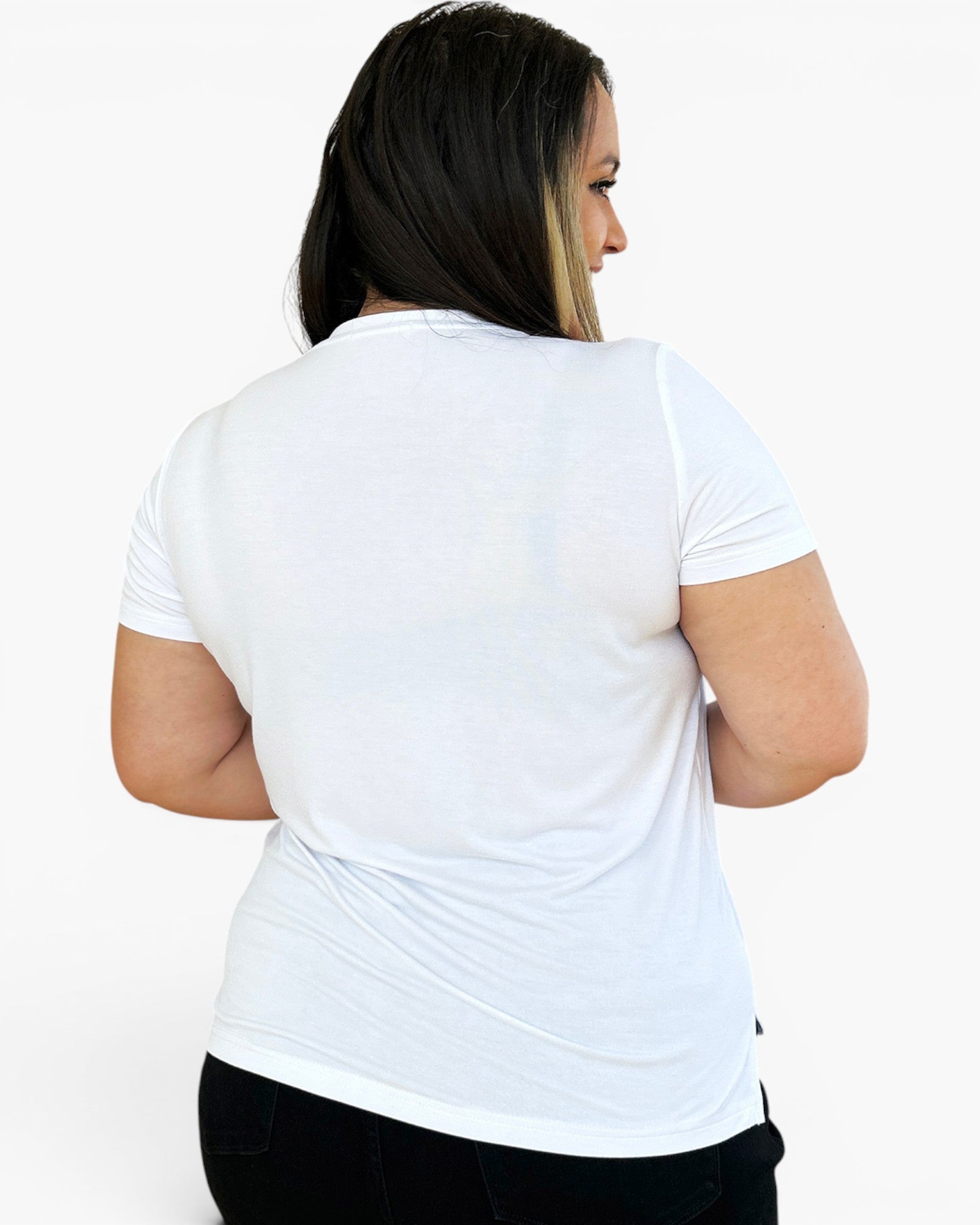 A woman shown from the back wearing a plain white short-sleeve crewneck t-shirt and black pants, photographed against a clean white studio background.