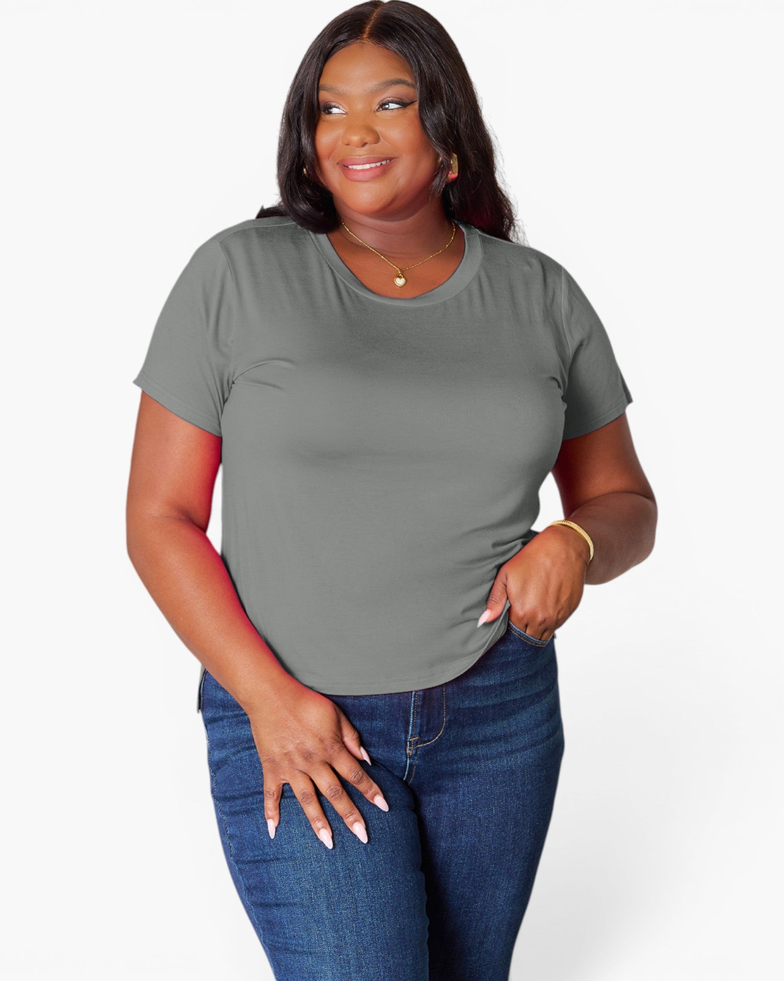 A woman modeling a short-sleeve crewneck t-shirt in a solid gray color, paired with blue jeans, against a plain light gray background.