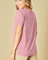 Woman wearing a pink t-shirt against a beige background
