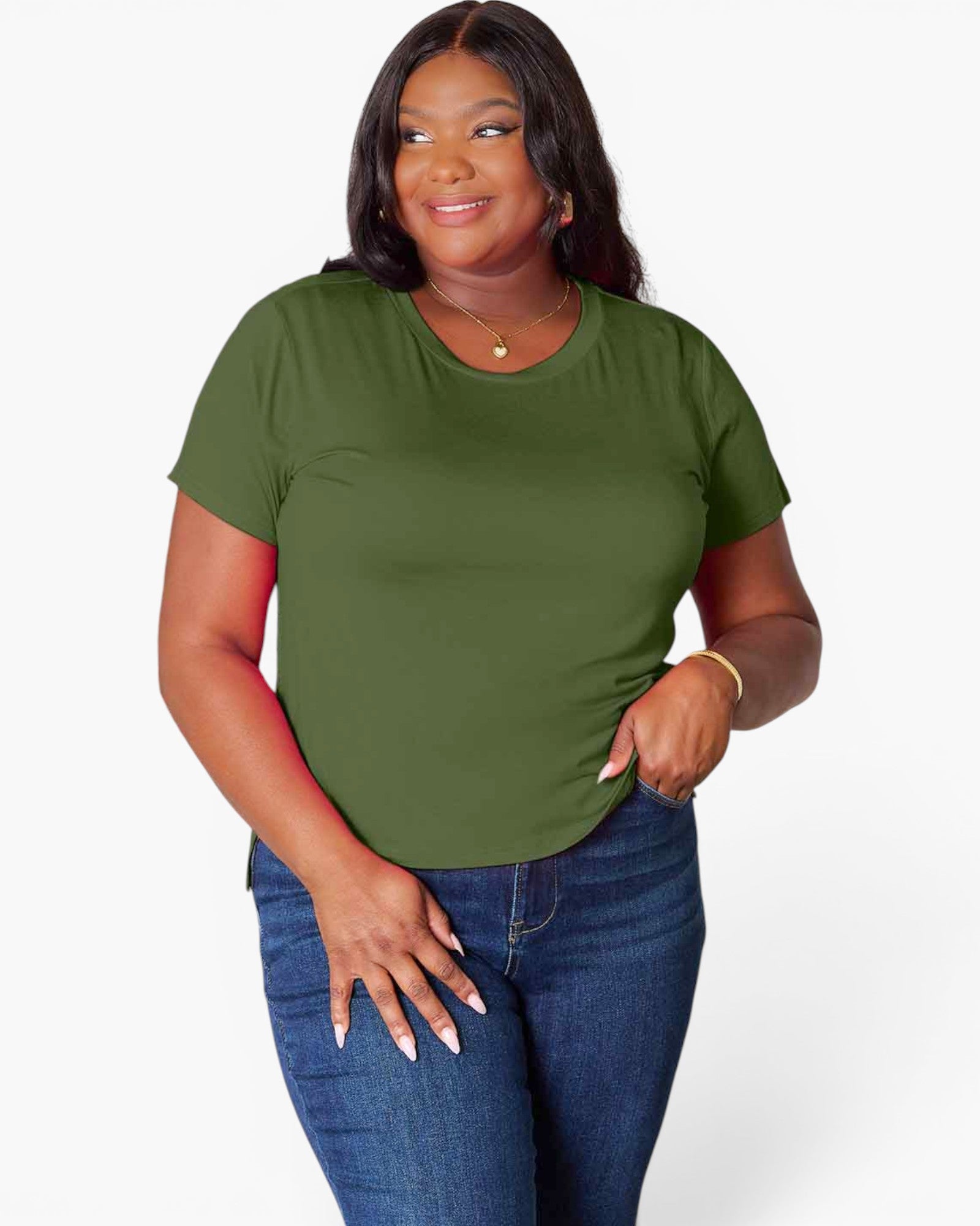 A woman modeling a short-sleeve crewneck t-shirt in olive green, paired with blue jeans, against a plain light gray background.