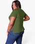 A woman modeling a short-sleeve olive green top from the back, paired with blue jeans, against a plain white background.