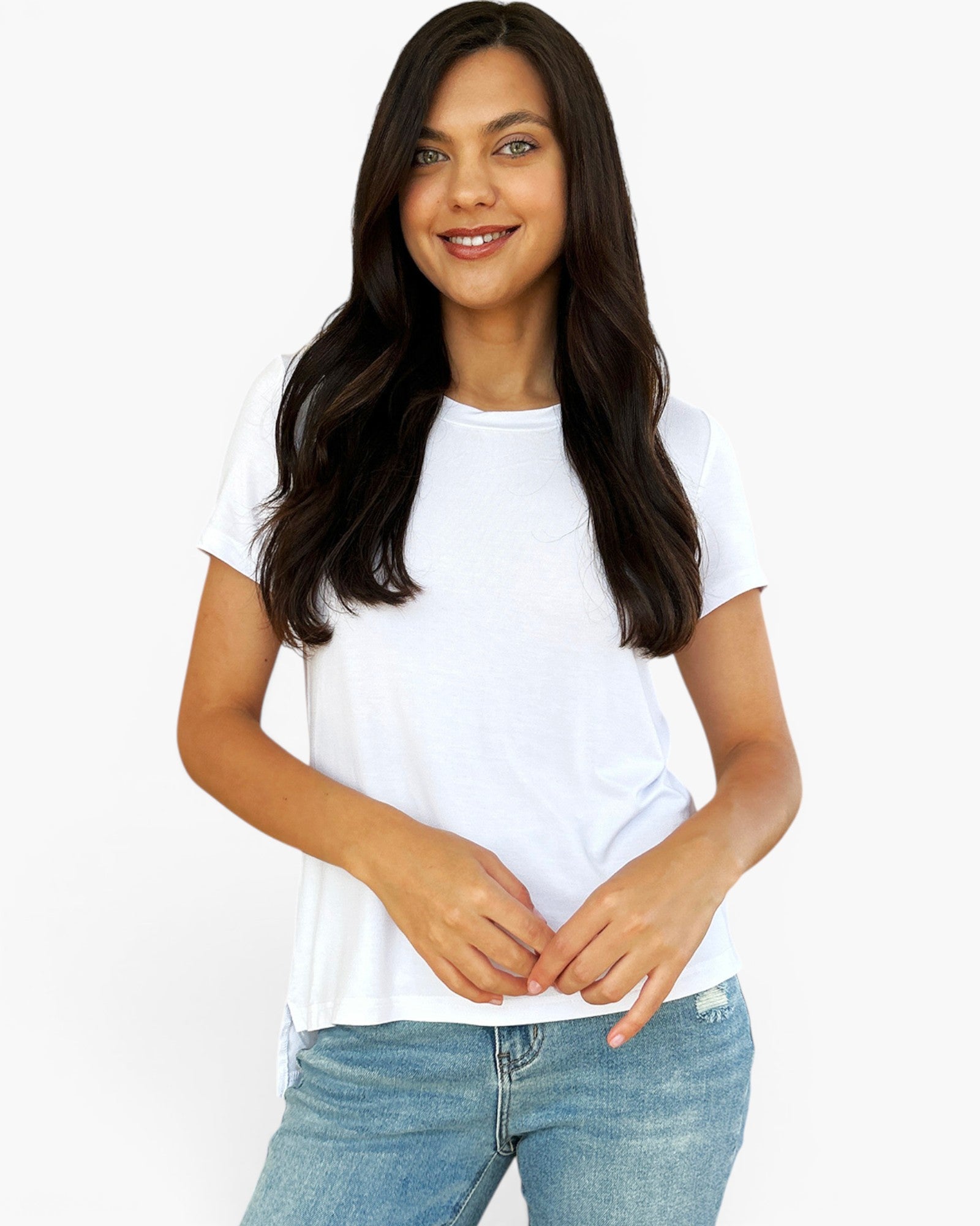 A woman with long dark hair wearing a white short-sleeve crewneck t-shirt and light blue jeans, standing against a plain white background.