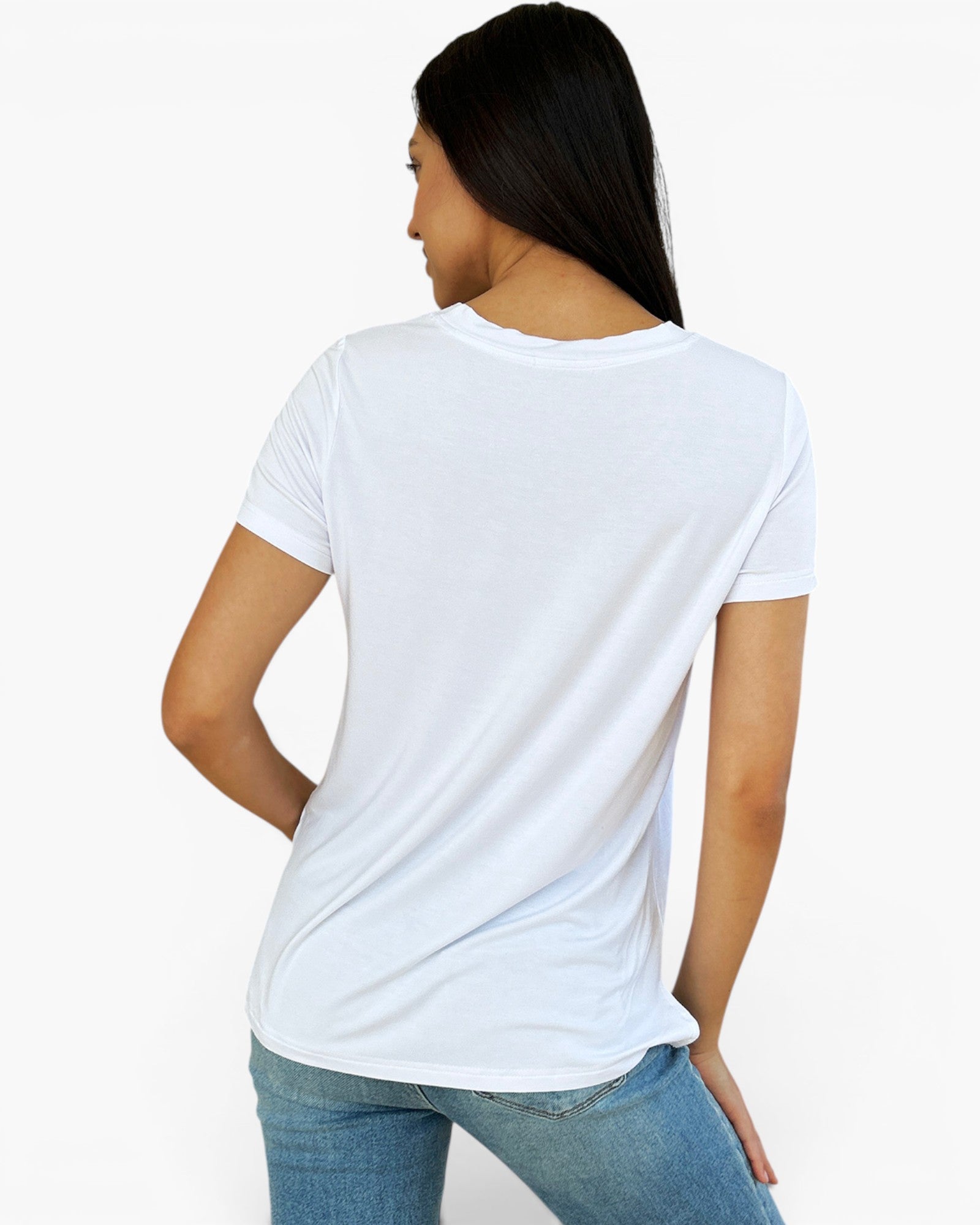 A woman shown from the back wearing a plain white short-sleeve crewneck t-shirt and blue jeans against a light gray studio background.